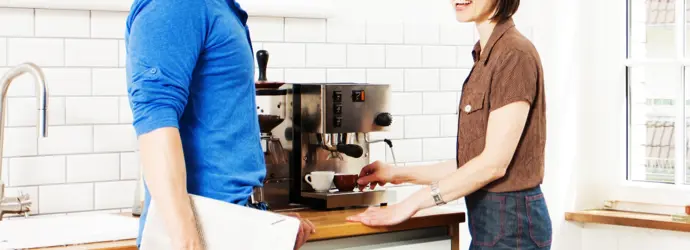 Deux personnes discutant devant une machine à café.