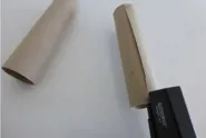 Une personne agrafe deux extrémités d'un tube en carton pour créer une base d'une longue-vue en carton solide.