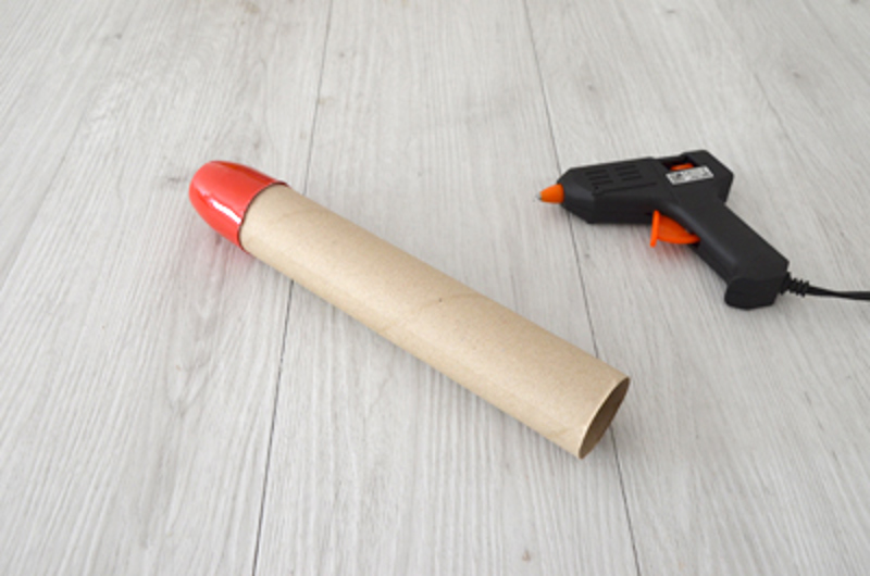 Un pot de yaout découpé collé à un tube en carton d’essuie-tout.