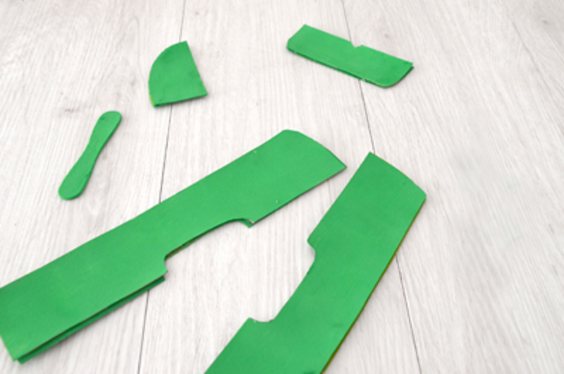 Différentes parties d’un avion en carton découpées dans du carton vert.