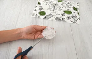 Mains d’une personne en train de découper un cercle de tissu.