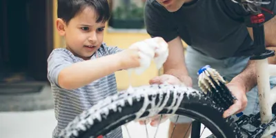 Vader en zoon maken een fiets schoon