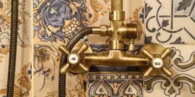Robinet de douche en laiton sur un fond en mosaïque