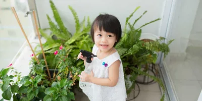 Une petite fille prend soin des plantes d'intérieur