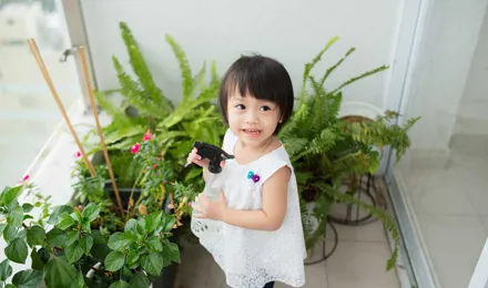 Une petite fille prend soin des plantes d'intérieur