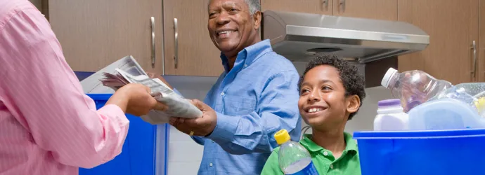 Grand-père apprend à un garçon à recycler dans la cuisine.