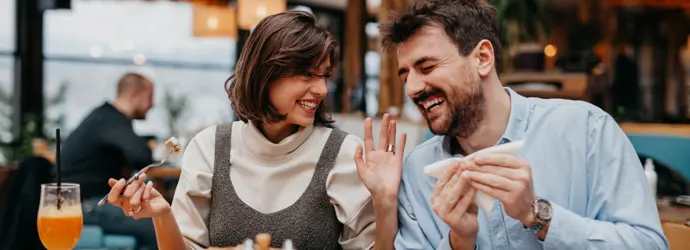 Couple souriant, dégustant un repas au restaurant.