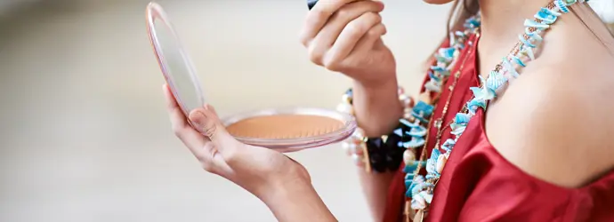 une jeune fille appliquant du rouge à lèvres