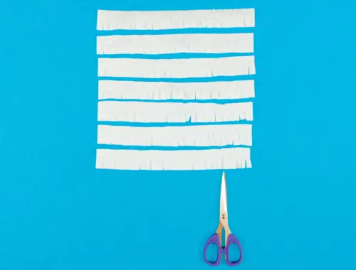 DIY pinata en carton recyclé, étape 7 : créer des franges à l'aide de feuilles d'essuie-tout et de ciseaux