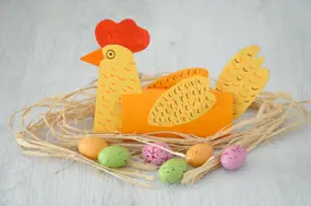Poule en papier et tube d’essuie-tout sur son nid, avec des œufs en chocolat